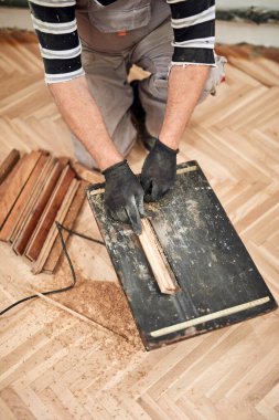 Tamirci eski parke döşemesini restore ediyor..