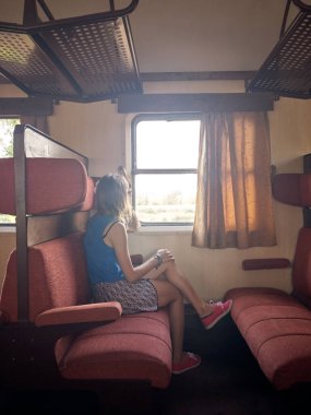 Eski bir tren vagonunda oturan kadın turist..