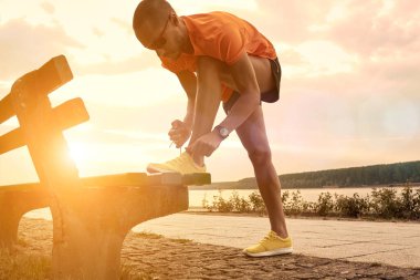 Sporcu nehir kenarında açık havada antrenman yapıyor..