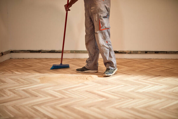 Repairman handyman restoring old parquet in the house.