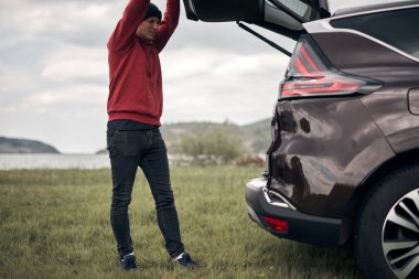 Doğada bir arabanın arka kapısından toplanıp boşaltılan bir kampçı..