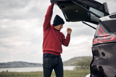 Doğada bir arabanın arka kapısından toplanıp boşaltılan bir kampçı..