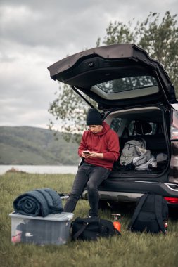 Doğada bir arabanın arka kapısından toplanıp boşaltılan bir kampçı..