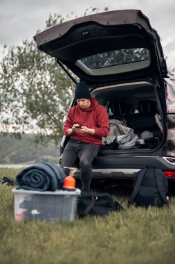 Doğada bir arabanın arka kapısından toplanıp boşaltılan bir kampçı..