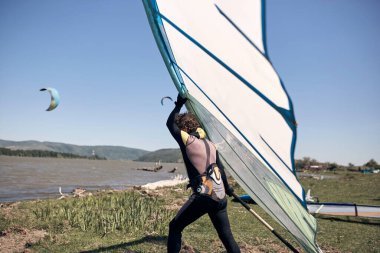 Rüzgârlı bir yaz gününde nehirde sörf yapan sörfçü..