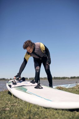 Rüzgârlı bir yaz gününde nehirde sörf yapan sörfçü..