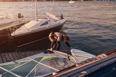 Rüzgar sörfçüsü nehirde rüzgarlı bir günde sörf yapıyor..