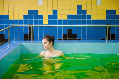 Woman in a pool with green water clipart