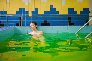 Woman in a pool with green water clipart