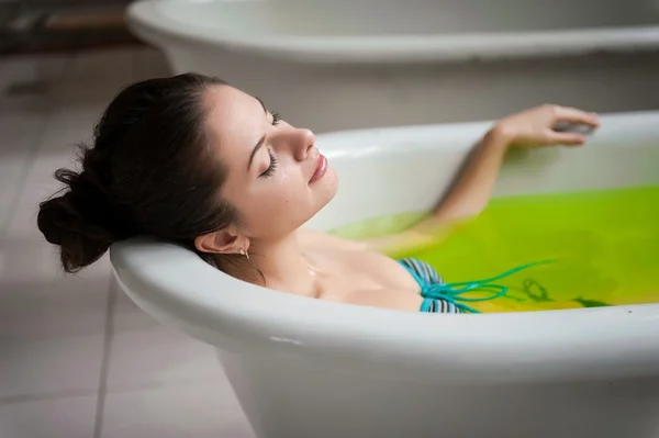 Žena ve vaně zelenou vodou — Stock fotografie