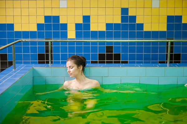 Mujer en una piscina con agua verde — Foto de Stock