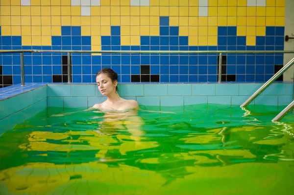 Woman in a pool with green water — Stock Photo, Image