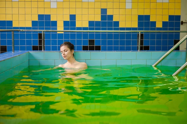 Mujer en una piscina con agua verde — Foto de Stock