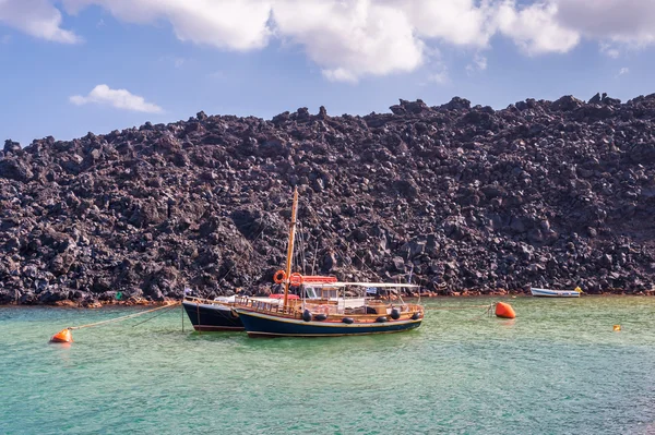 Boats moored to large boulders of lava — Stock Photo, Image