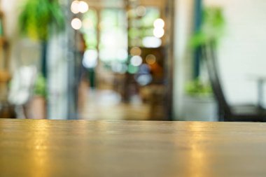 Kafe 'deki ahşap masa ve bokeh' in yumuşak odak arkaplanı.