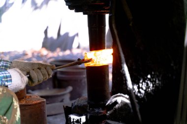 Demirci çeşitli aletler yapmak için çok sıcak demir dövüyor..