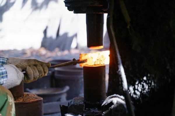 鍛冶屋は様々な道具を作るために非常に熱い鉄を鍛造しています — ストック写真