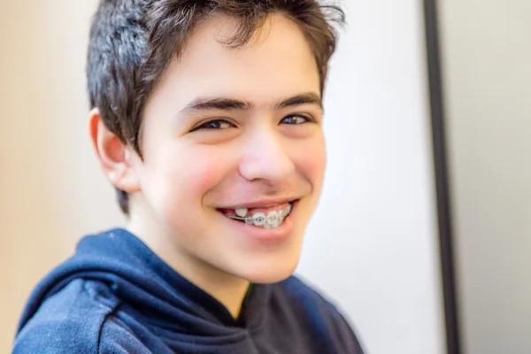 caucasian boy happy and smiling with braces on teeth