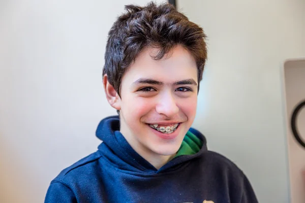 caucasian boy happy and smiling with braces on teeth