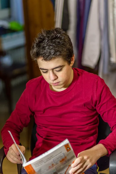 Кавказский Мальчик Читает Книгу Выполняя Домашние Работы — стоковое фото
