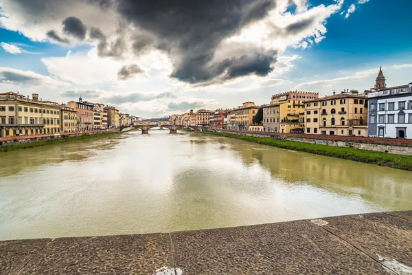 河流穿过佛罗伦萨的历史建筑在多云的天空下 — 图库照片