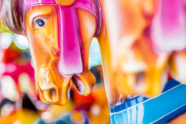 close up of merry-go-round seats, galloping horses