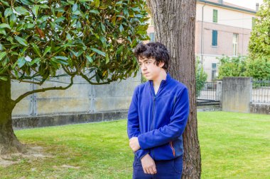 genç çocuk bahçede bir catalpa ağacının gövdesine yaslanmış düşünceleri kayboldu