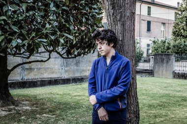 genç çocuk bahçede bir catalpa ağacının gövdesine yaslanmış düşünceleri kayboldu