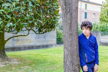 genç çocuk bahçede bir catalpa ağacının gövdesine yaslanmış düşünceleri kayboldu