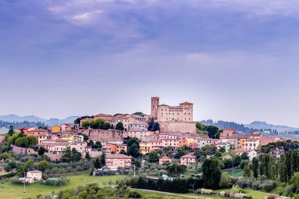 Cesena, İtalya yakınlarındaki büyüleyici dağ kasabası Longiano'nun renkli evlerine bakan ortaçağ kalesi