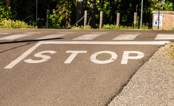 the word stop written on a paved road