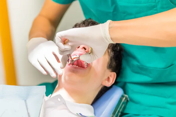 ortodontist permperile bir bebek diş çekerken diş hekimi sandalyede adam