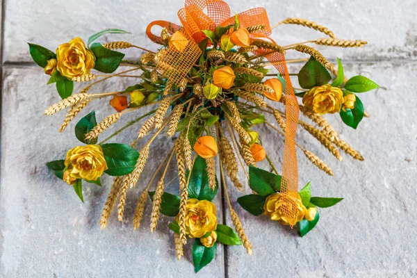 floral decoration with yellow roses, green leaves and blonde ears of corn