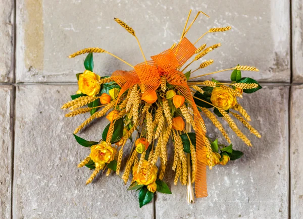 floral decoration with yellow roses, green leaves and blonde ears of corn