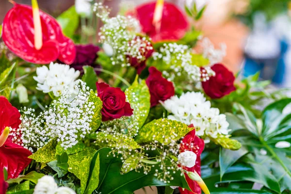 bouquet of red and white flowers with green leaves