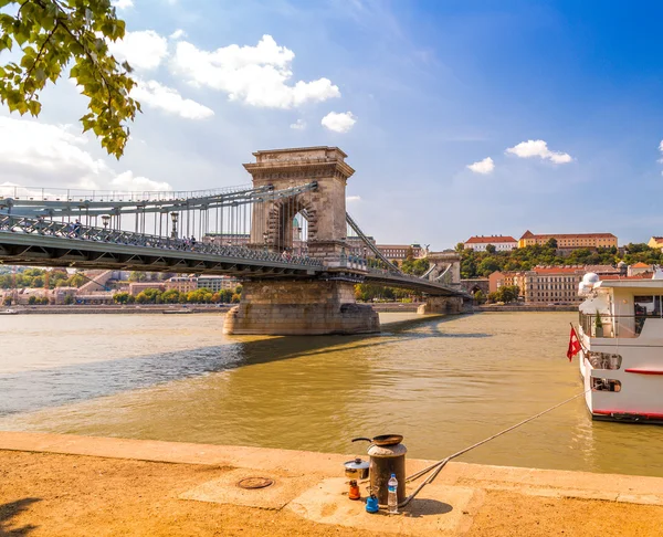 pan and camp stove on bollard on  the shore of the Danube River, near The Chain Bridge in Budapest seen from