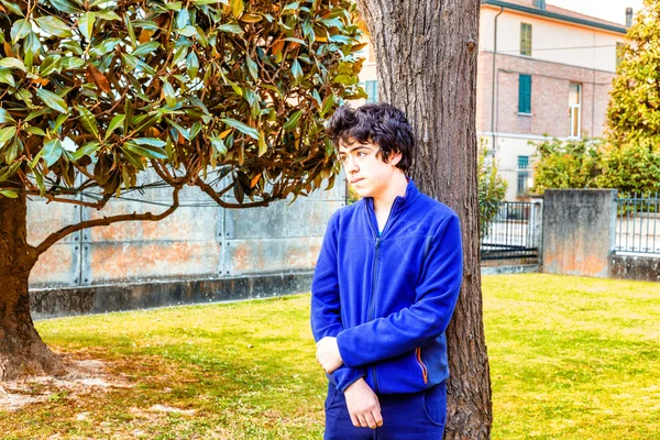 genç çocuk bahçede bir catalpa ağacının gövdesine yaslanmış düşünceleri kayboldu