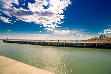 İtalya'da Adriyatik kıyısında deniz üzerinde kırmızı deniz feneri ile beton iskele