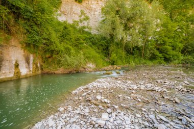 İtalya'da Emilia Romagna yeşil tepelerüzerinde bir nehrin yatağında berrak ve şeffaf suları