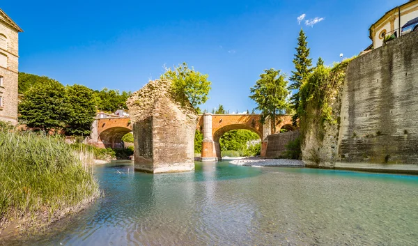 Romagna, İtalya'da tepelerde küçük bir köyde kayalık yığını etrafında ve on ikinci yüzyıl köprüsü altında çalışan nehir suları