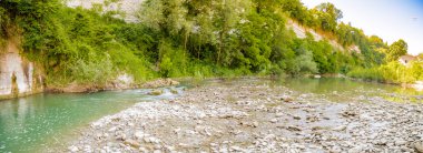 İtalya'da Emilia Romagna yeşil tepelerüzerinde bir nehrin yatağında berrak ve şeffaf suları