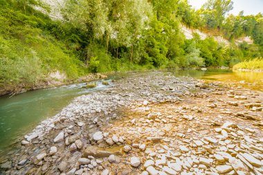 İtalya'da Emilia Romagna yeşil tepelerüzerinde bir nehrin yatağında berrak ve şeffaf suları