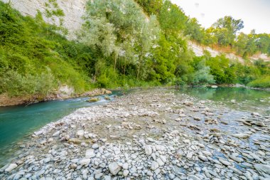 İtalya'da Emilia Romagna yeşil tepelerüzerinde bir nehrin yatağında berrak ve şeffaf suları