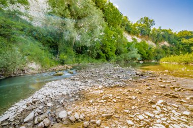 İtalya'da Emilia Romagna yeşil tepelerüzerinde bir nehrin yatağında berrak ve şeffaf suları