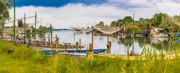 berthed old ships and fishing huts in the quiet of brackish lagoon in Italy