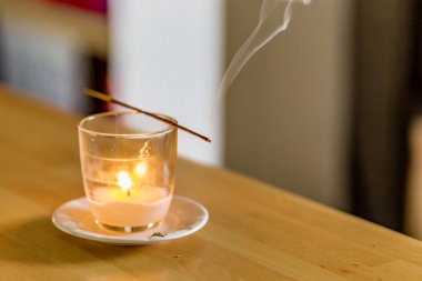 mum ile bir cam üzerinde düzenlenen yanan tütsü bir sopa