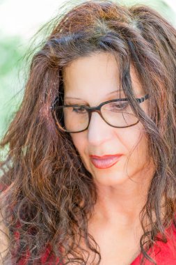 kırmızı elbise ve uzun kahverengi dalgalı saçlı muhteşem orta yaşlı kadın nerdy gözlük bir çift giyen okuyor