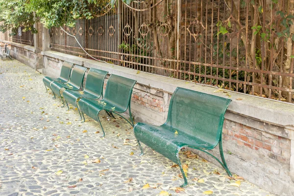 Bancos Ferro Verde Alinhados Uma Rua Paralelepípedos Com Folhas Pólen — Fotografia de Stock