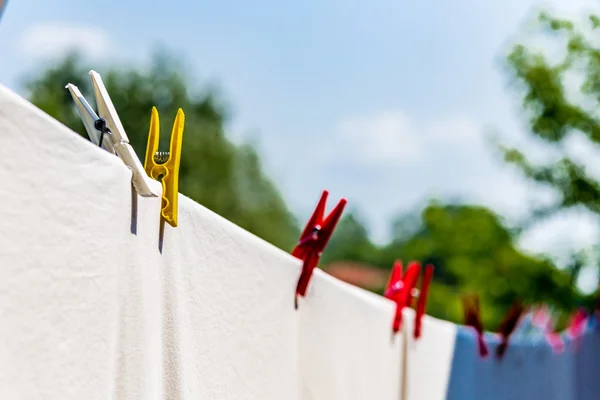 clothes hung out to dry with pegs, but after washing they are still dirty