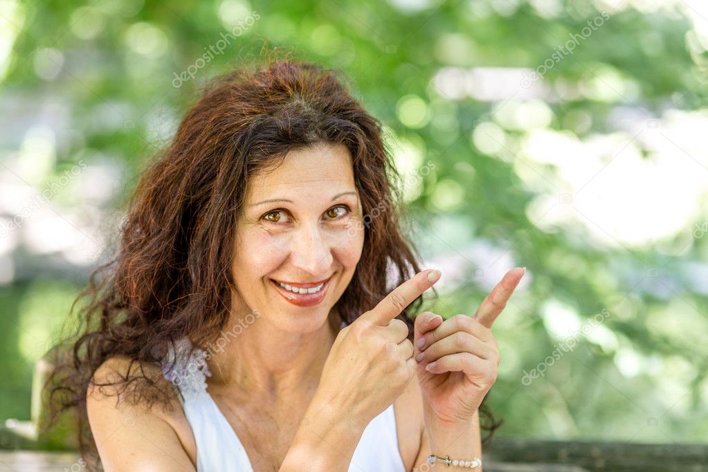 happy attractive woman pointing to the side with both hands